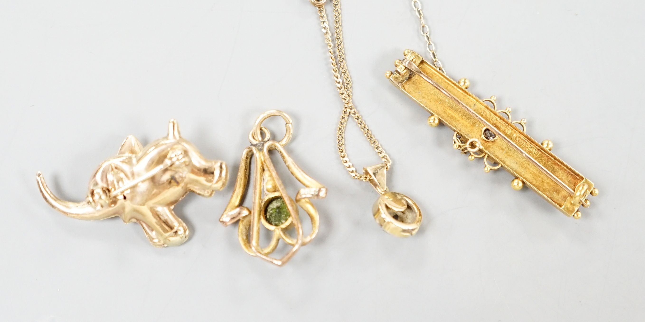 A yellow metal and diamond set clasp, now mounted as a pendant on later 9k chain, a yellow metal and diamond set elephant brooch, 31mm, a yellow metal and green stone doublet set pendant and a 15ct and diamond set bar br